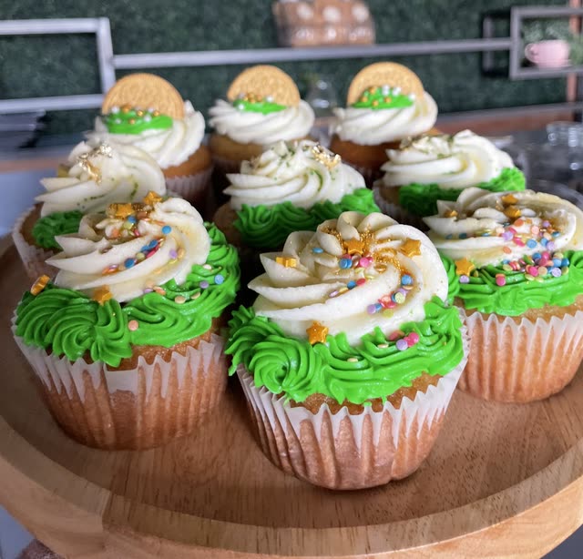 Cupcakes with green and cream swirled frosting, rainbow sprinkles and gold stars
